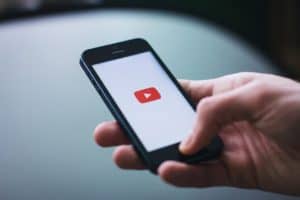 man holding phone and browsing youtube