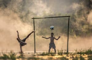 kids playing soccer in a field