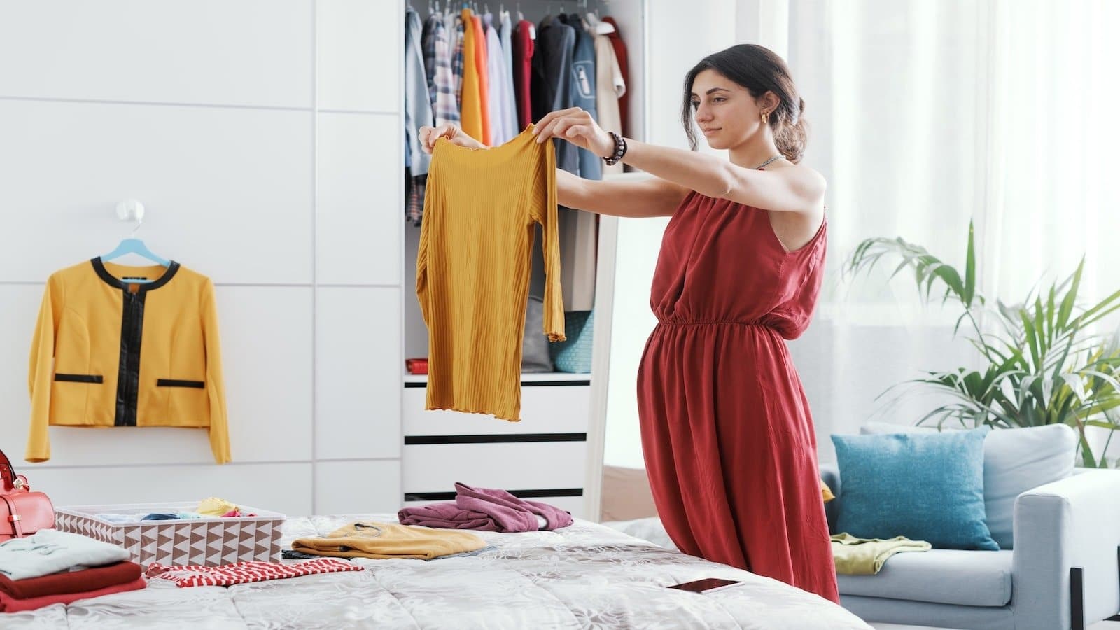 woman folding clothes looking through decluttering organizing.