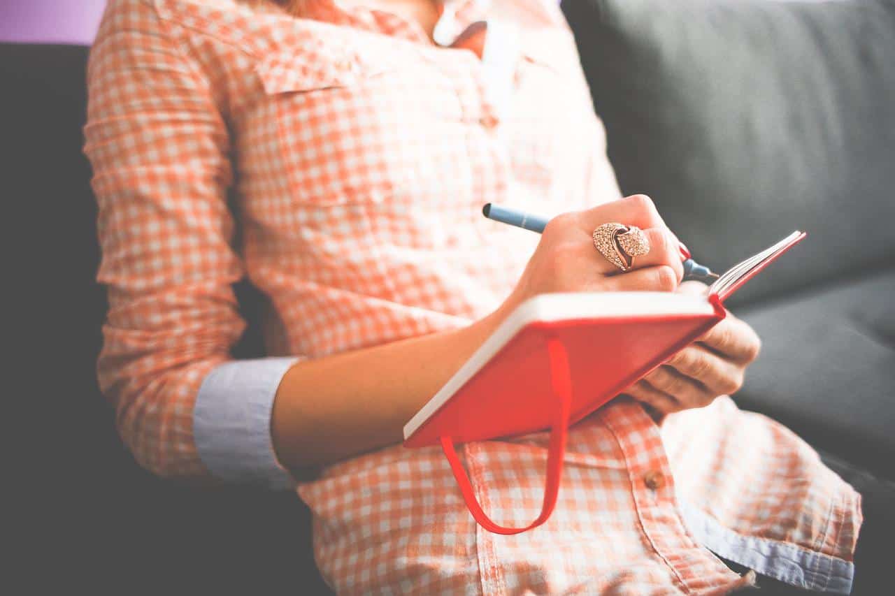 woman writing self care affirmations