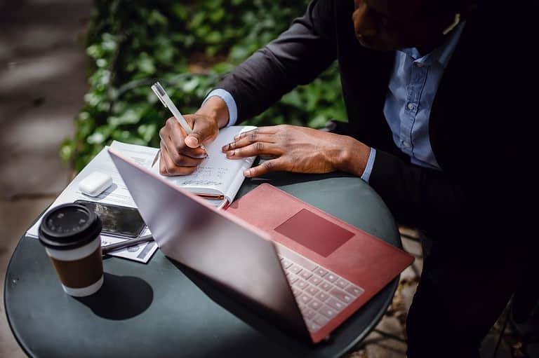 man writing in notebook