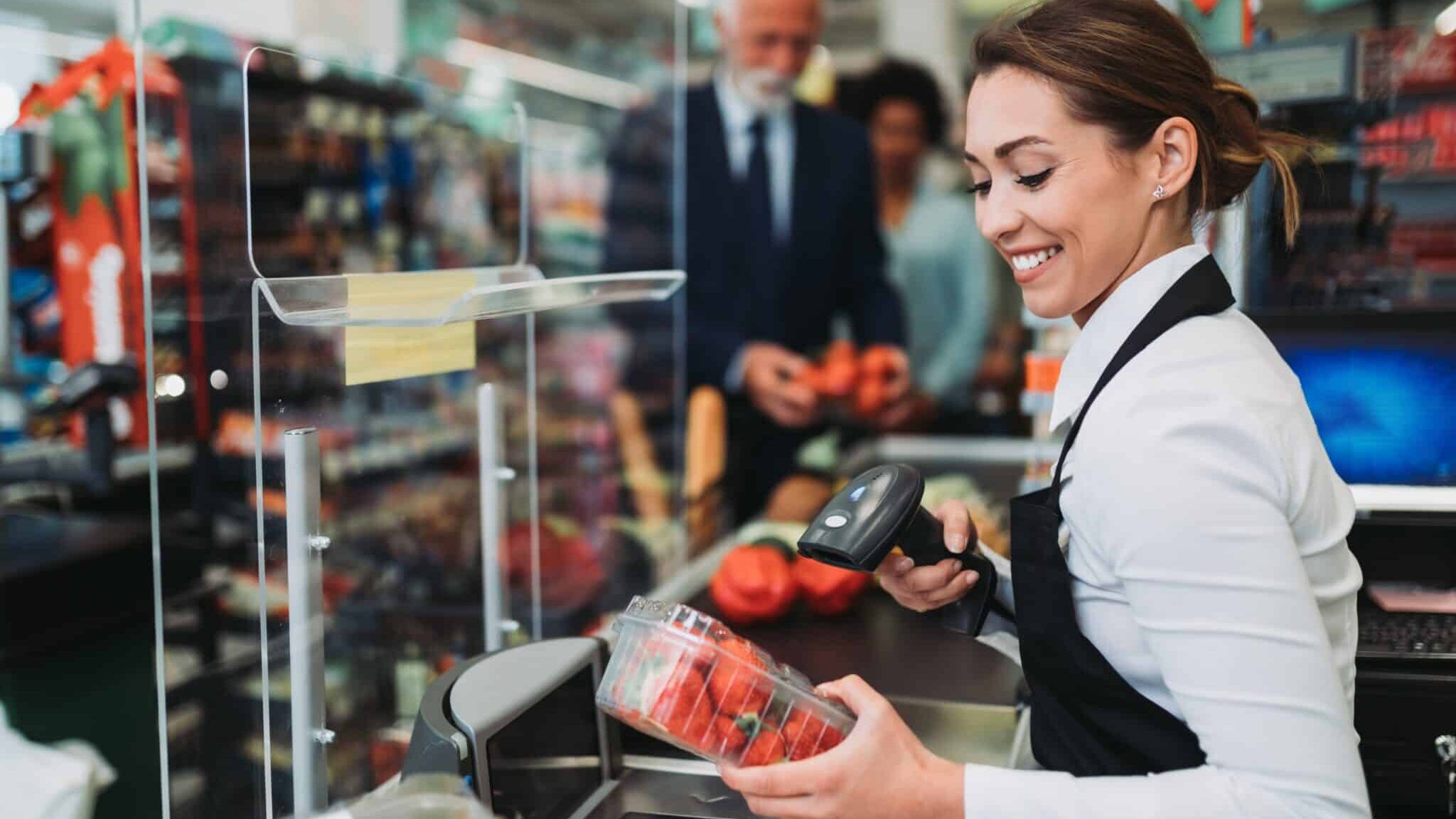 Beautiful smiling cashier working at a grocery store.
