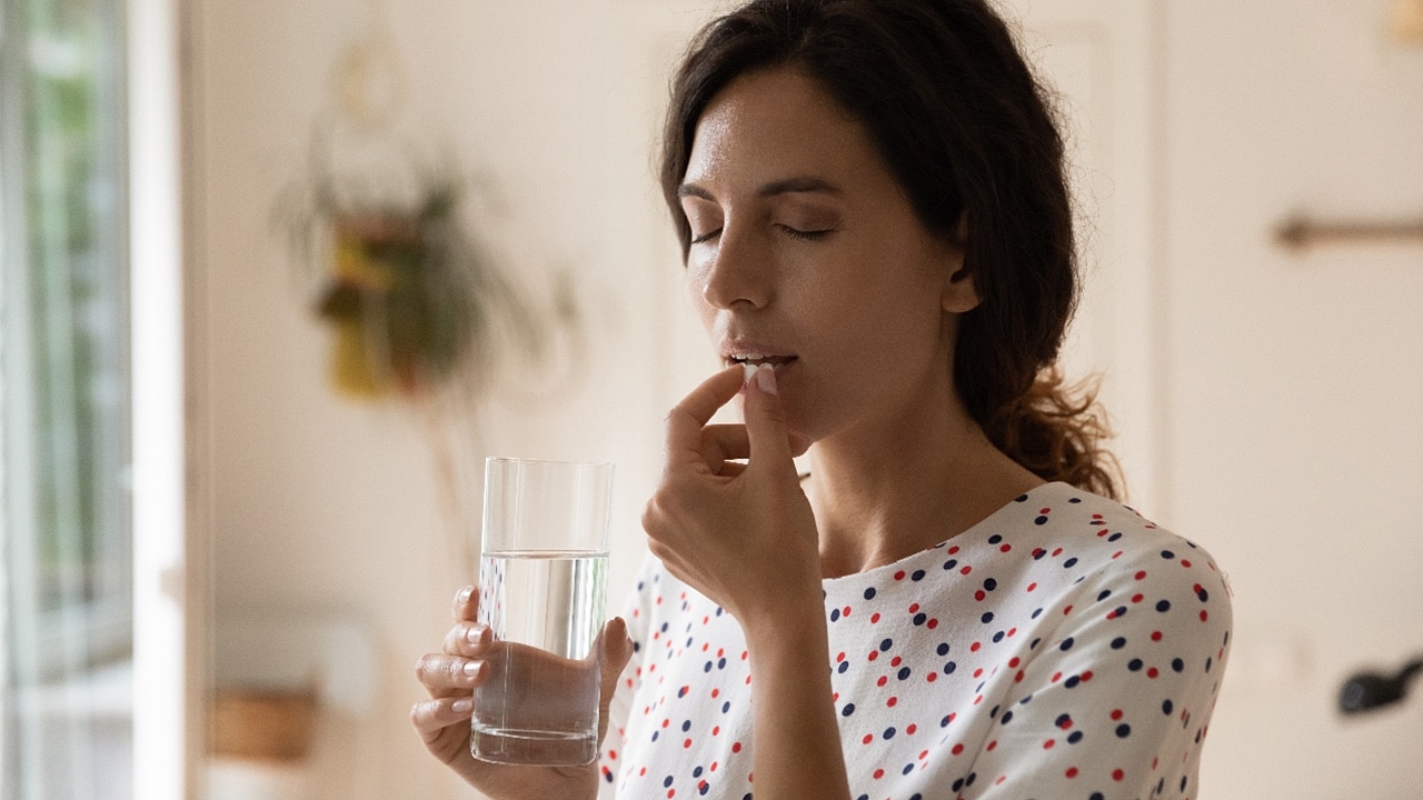 Woman taking medication, medicine, sick, ill, unwell, insomnia, melatonin
