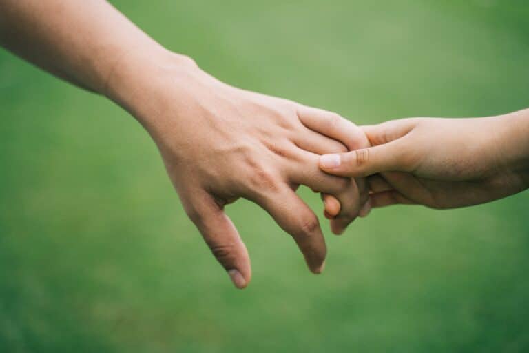 two siblings holding hands