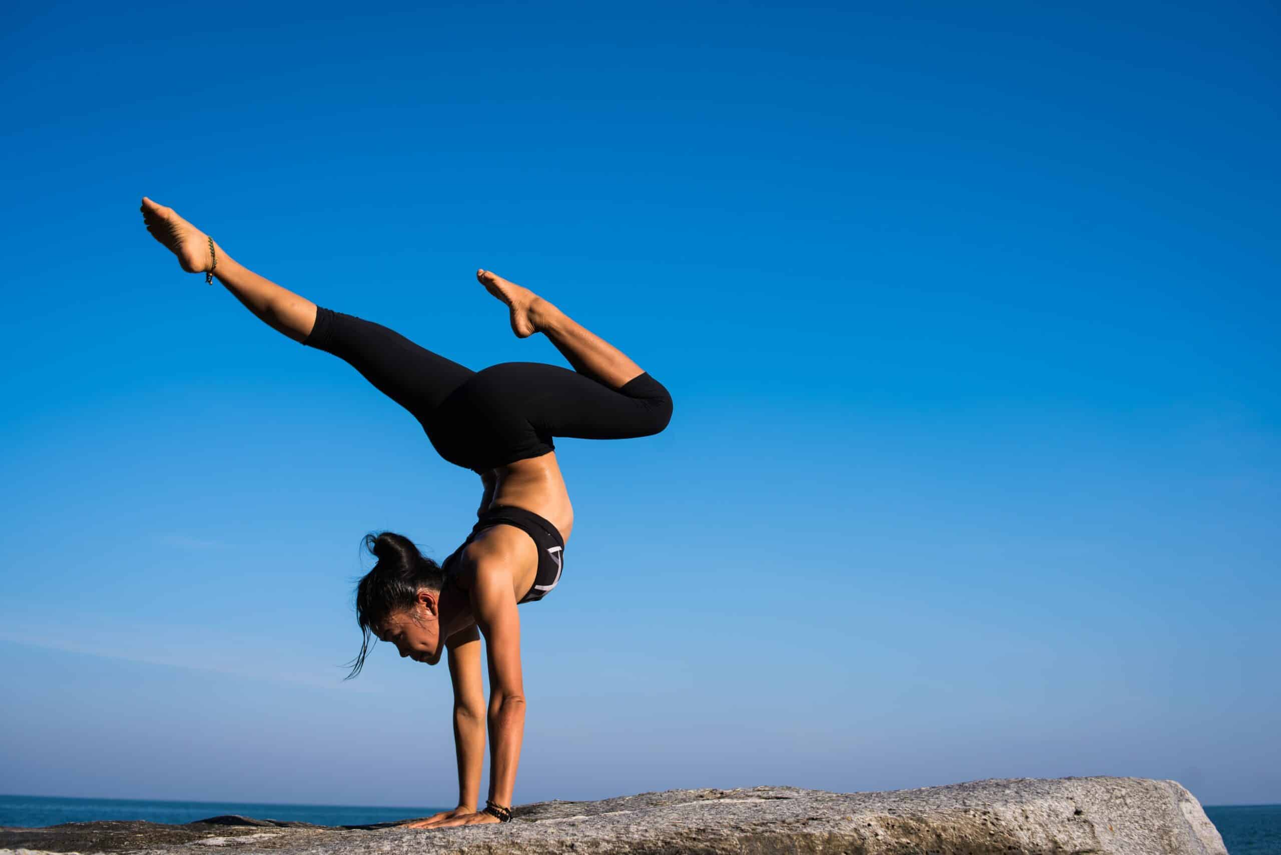 woman doing yoga by the ocean