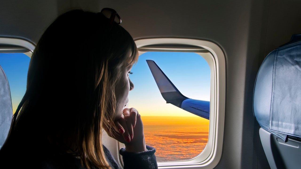 Woman looking out the window during her flight