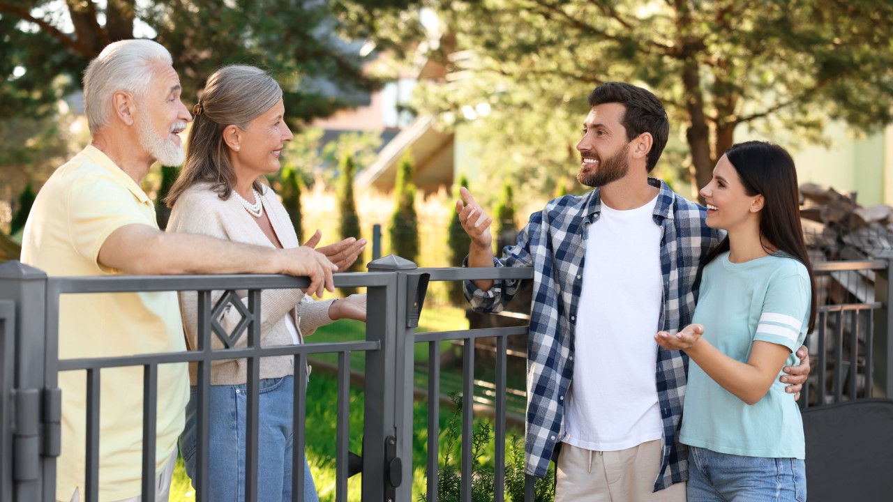 Friendly,Relationship,With,Neighbours.,Young,Family,Talking,To,Elderly,Couple