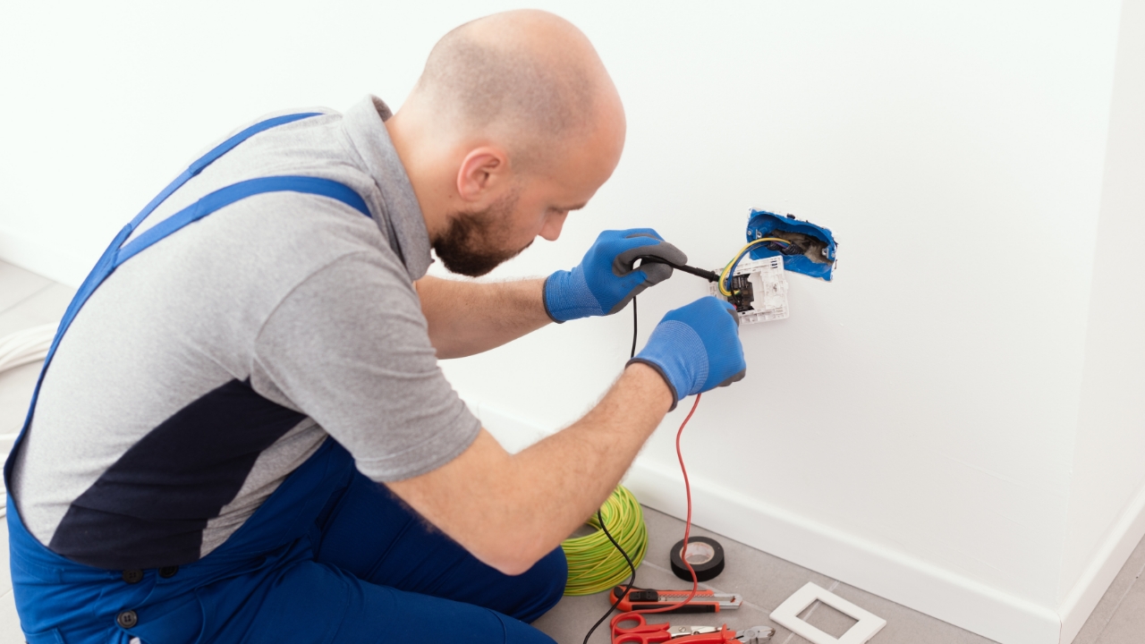 Man rewiring an electrical outlet, electrician