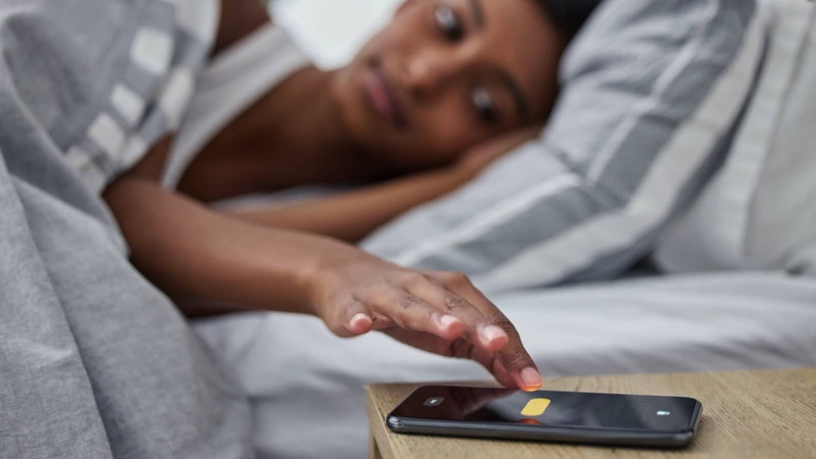 Woman hitting snooze in mobile