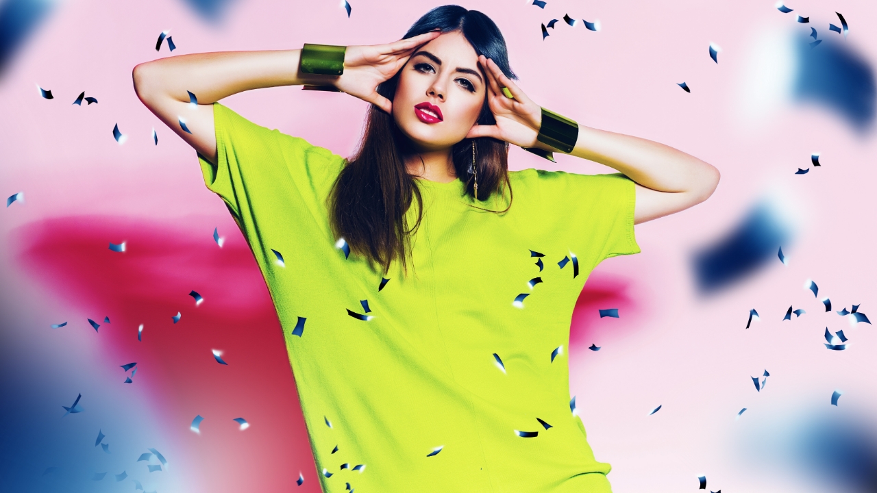 Woman wearing neon shirt with confetti in air