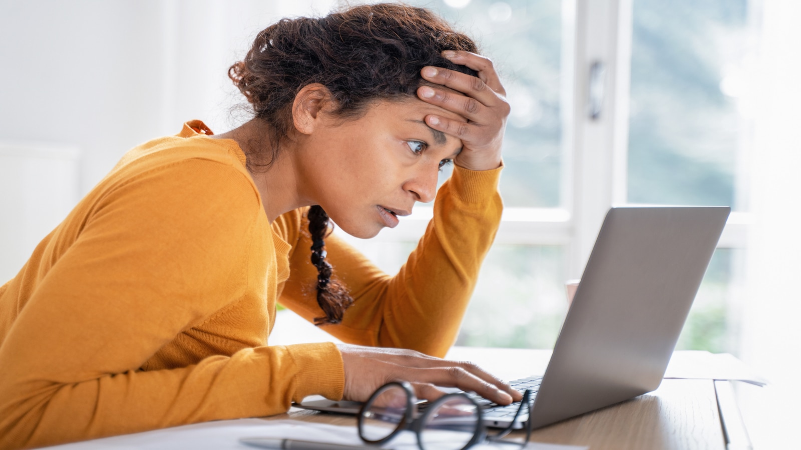 woman shocked looking at computer screen.