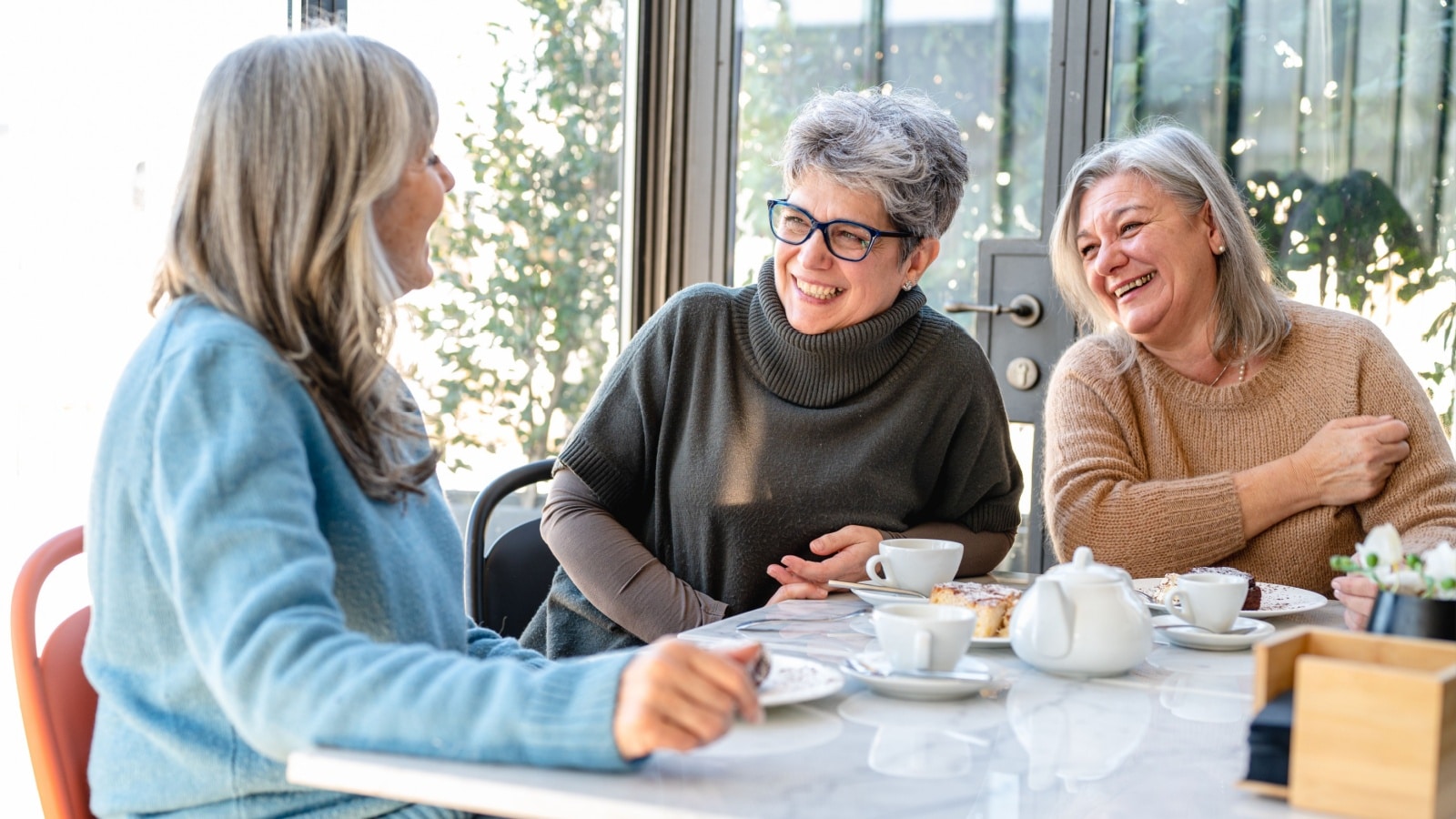 Group of older women have breakfast in a cafe.