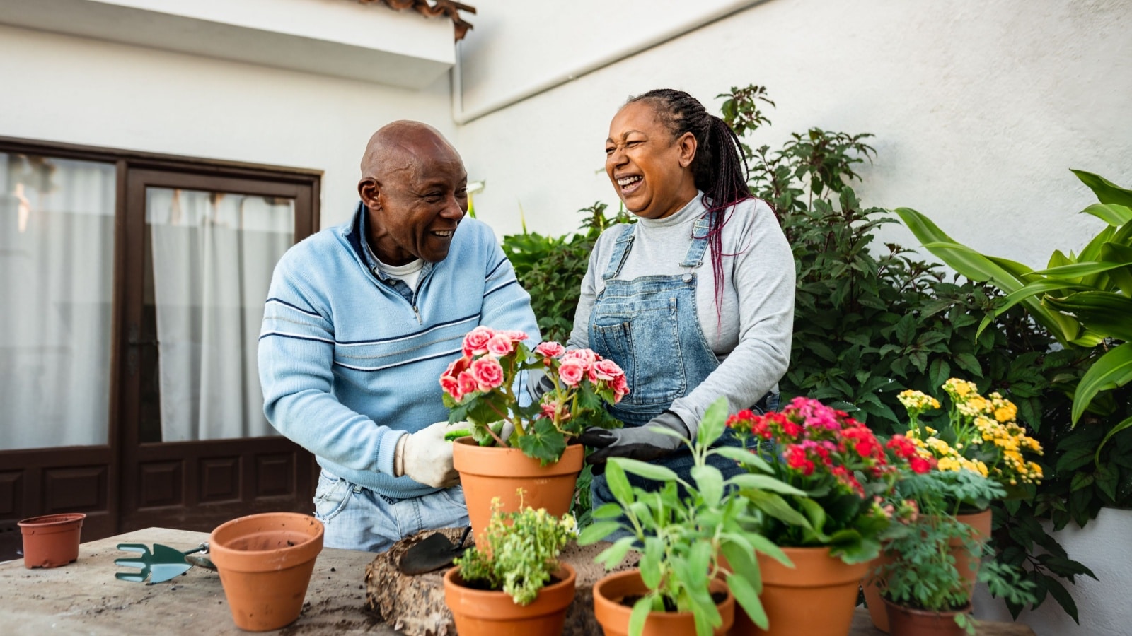 Happy older couple gardening together at home.