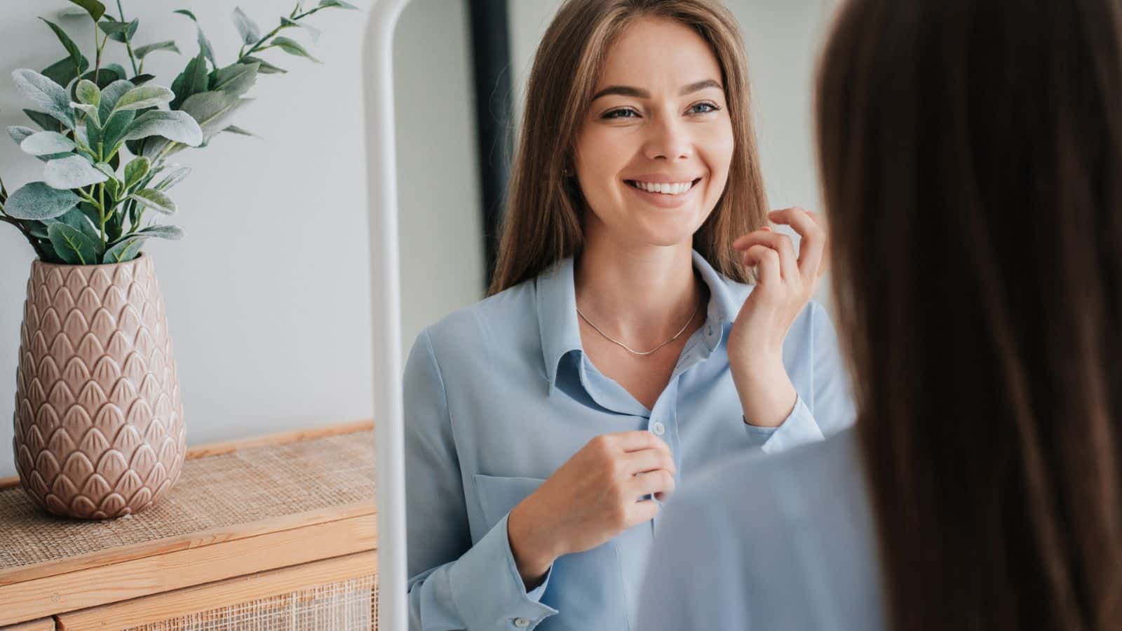 Happy young woman smiling in mirror.