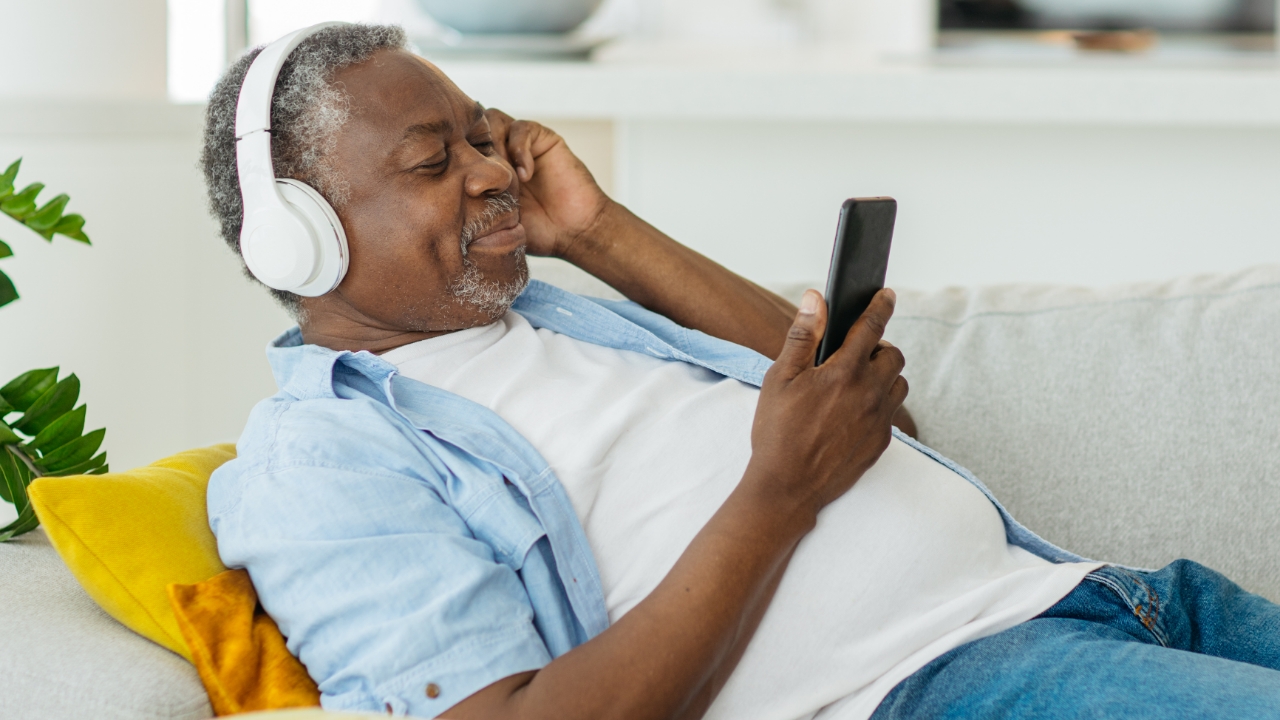 Elderly man wearing headphones listening to music on smartphone, relax, relaxation