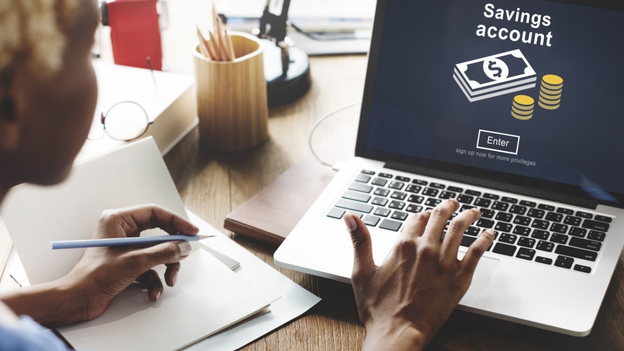 Woman sitting at desk on her computer analyzing her savings account
