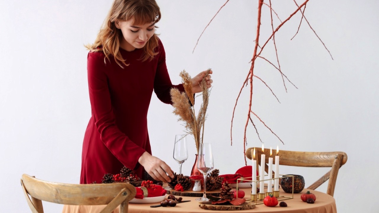 Woman arranging table for thanksgiving dinner