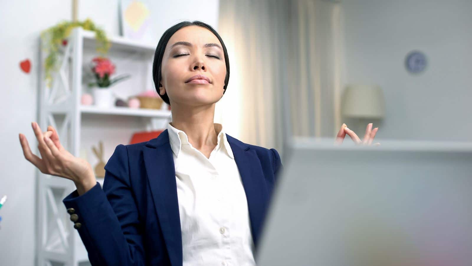 Young business lady meditating front laptop.