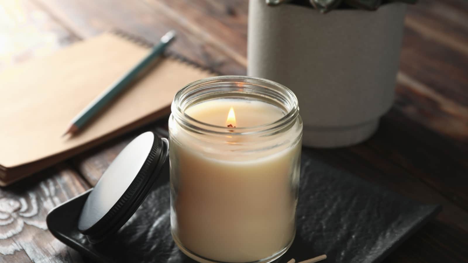 Burning candle in glass jar.