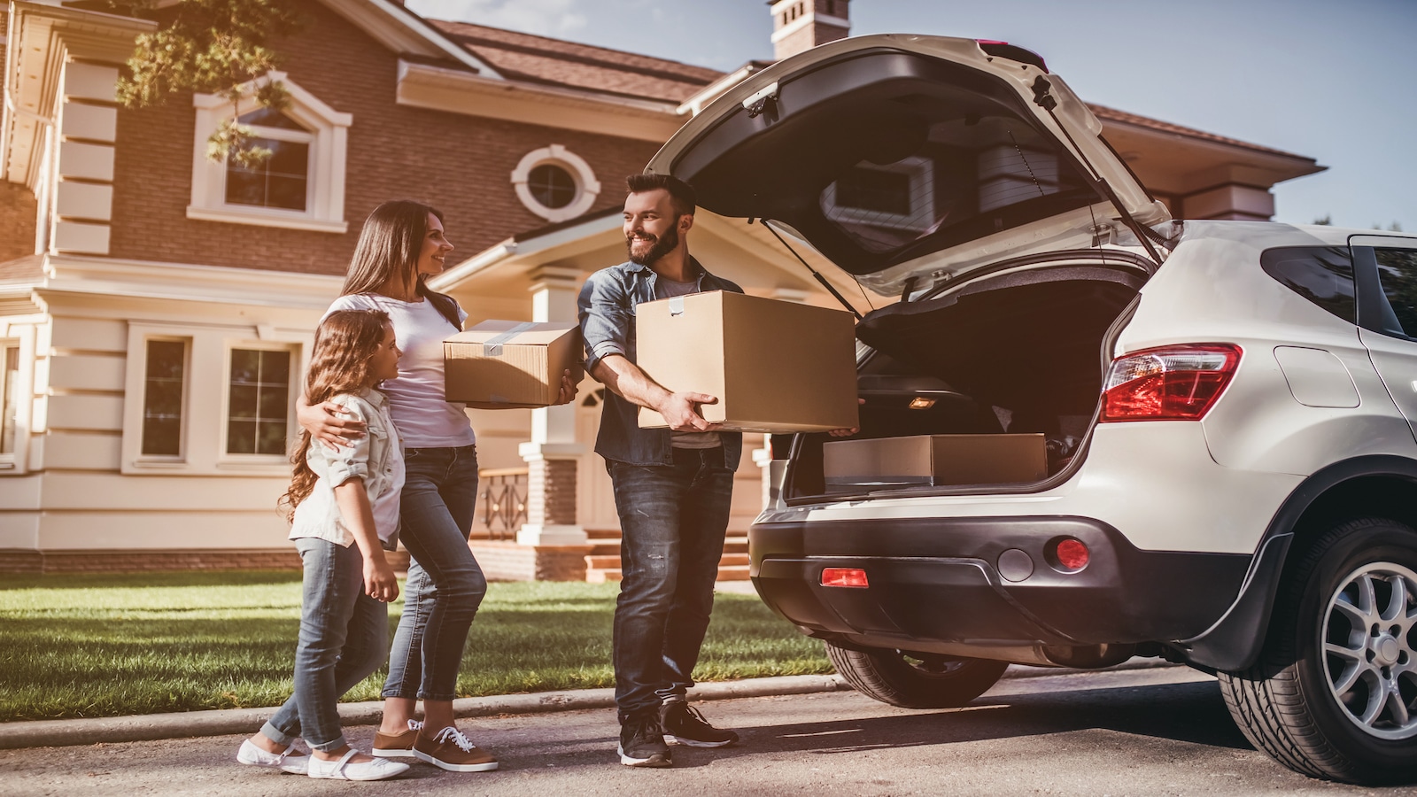 family moving into new house car parked in front.
