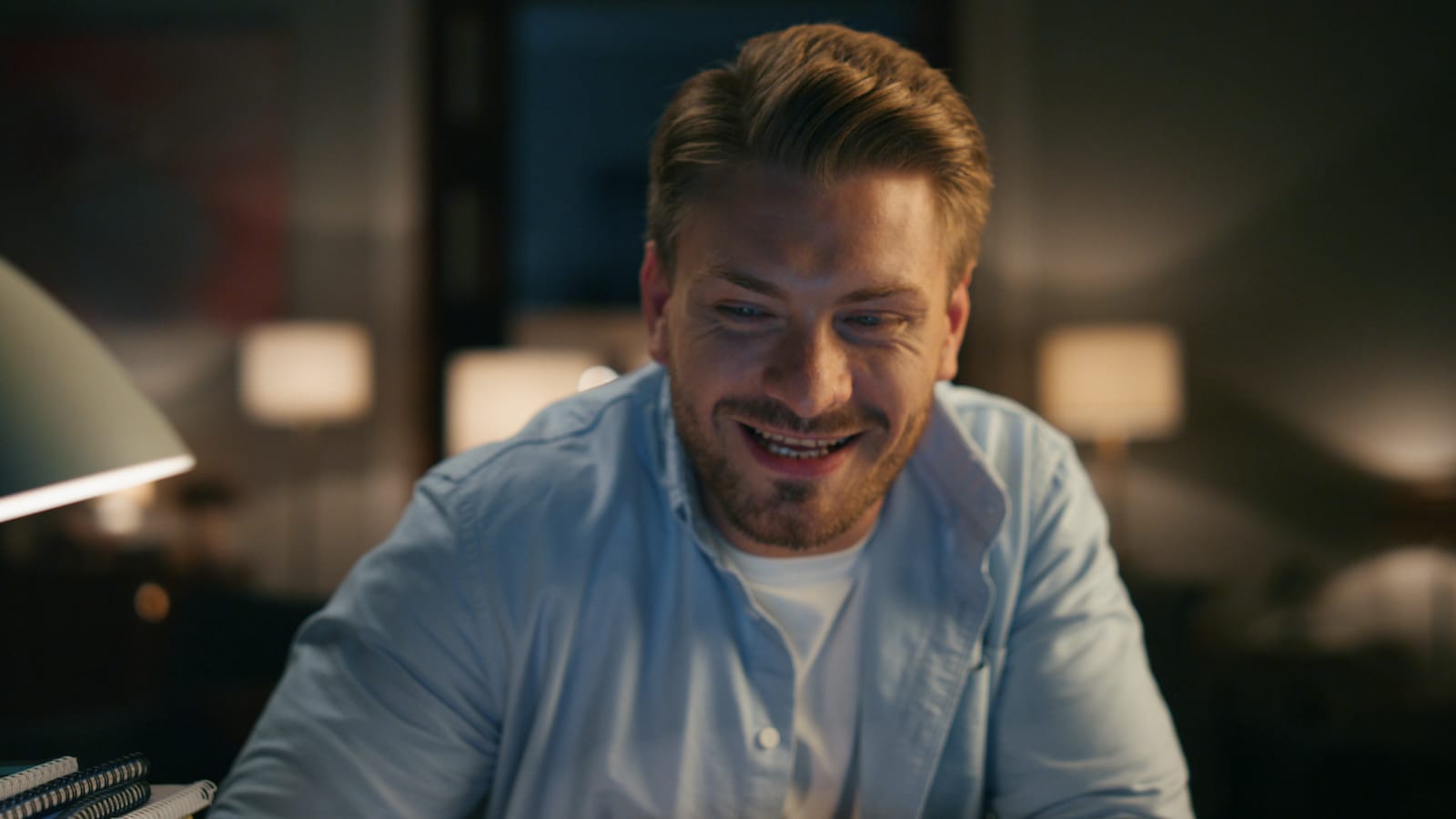 Close up man laughing at home at night having fun.