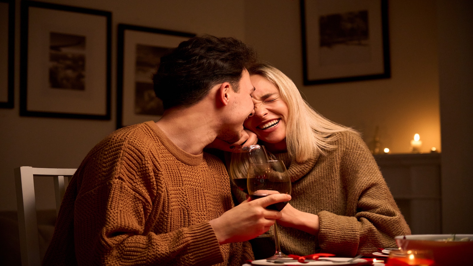 Happy young couple at home at night laughing.
