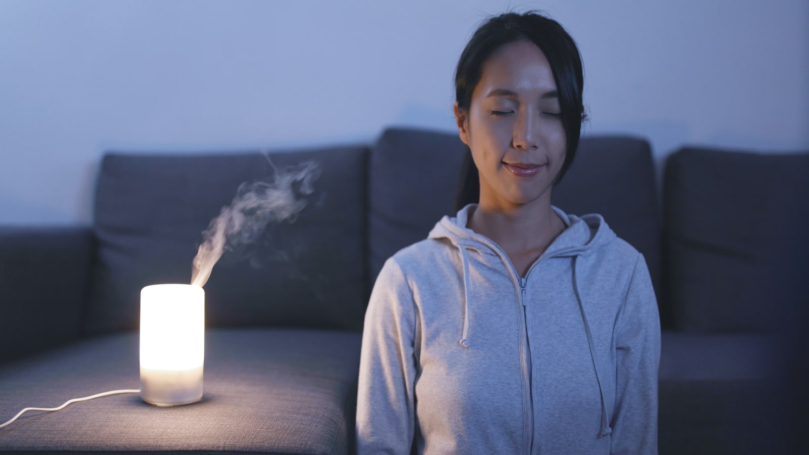 Woman deep breathing at night before bed.