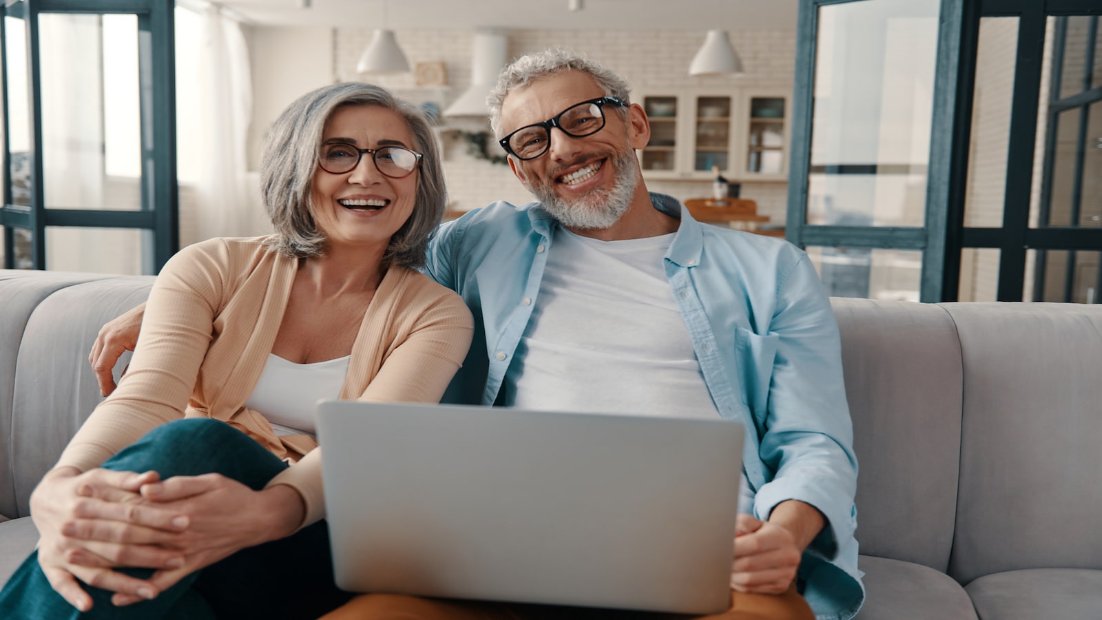 Happy retired couple looking at laptop together.
