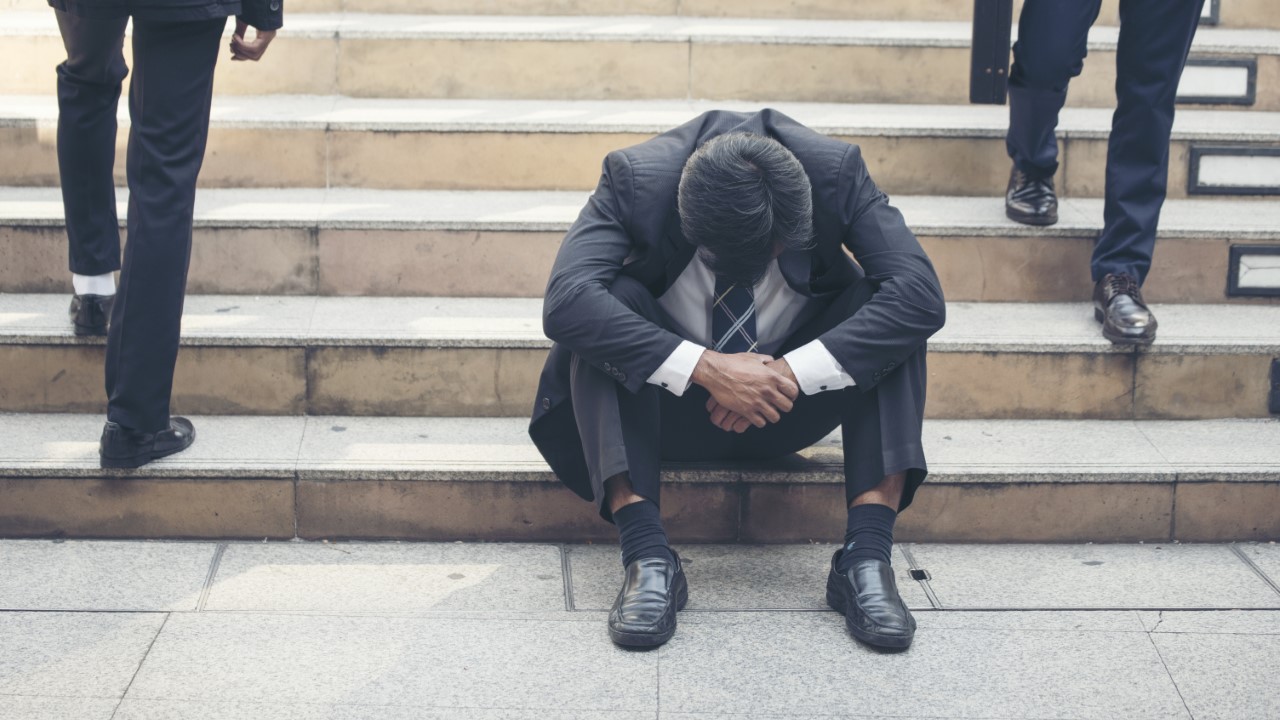 Defeated man sitting on steps after quitting job