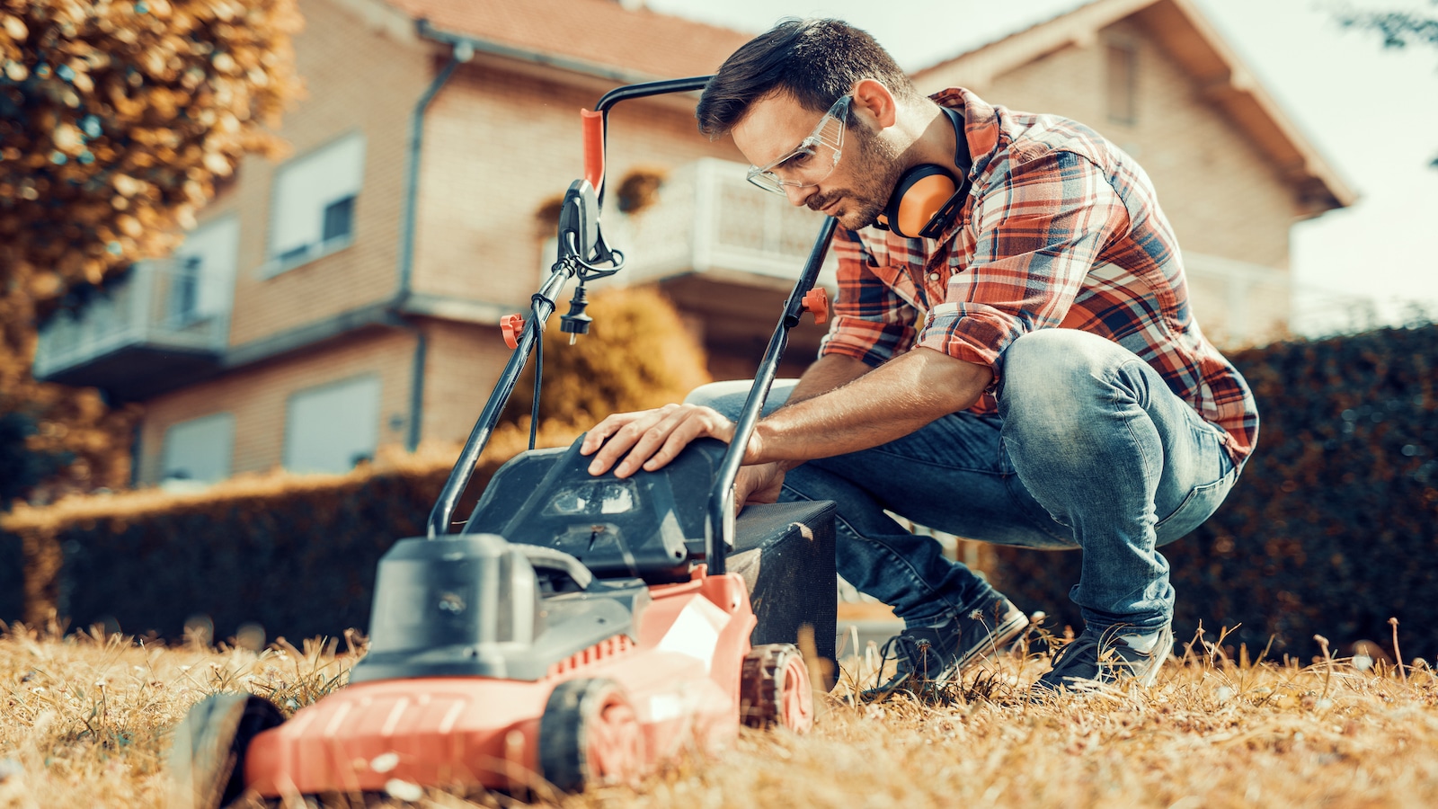 man cutting grass wtih lawn mower.