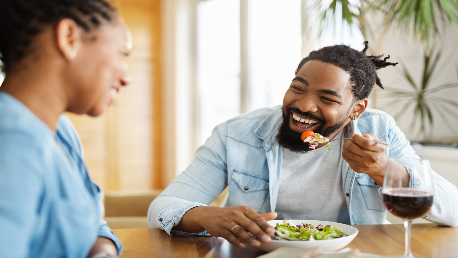 man laughing eating salad with wife girlfriend.