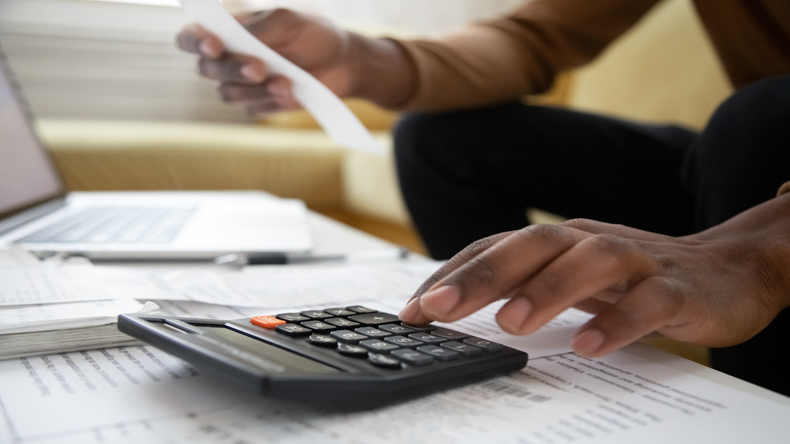man hand shown on calculator paying bills.