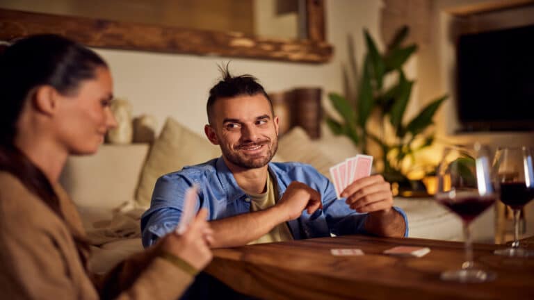 Man playing cards at home with girlfriend.