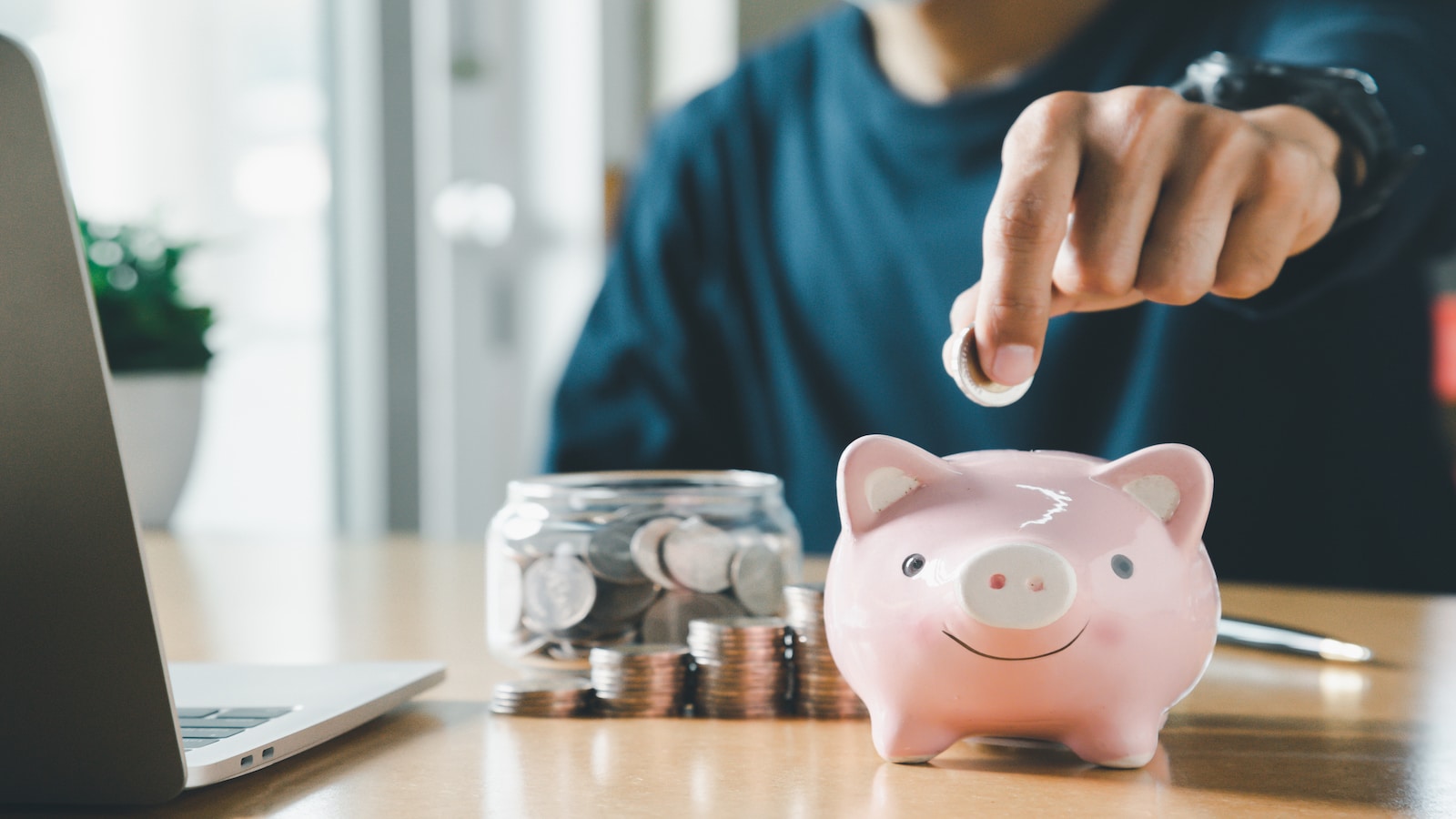 man saving money in piggy bank.