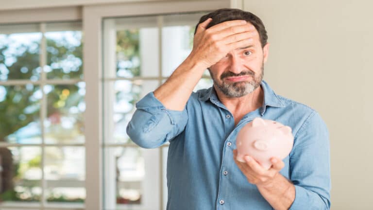 man shocked saving money with piggy bank.