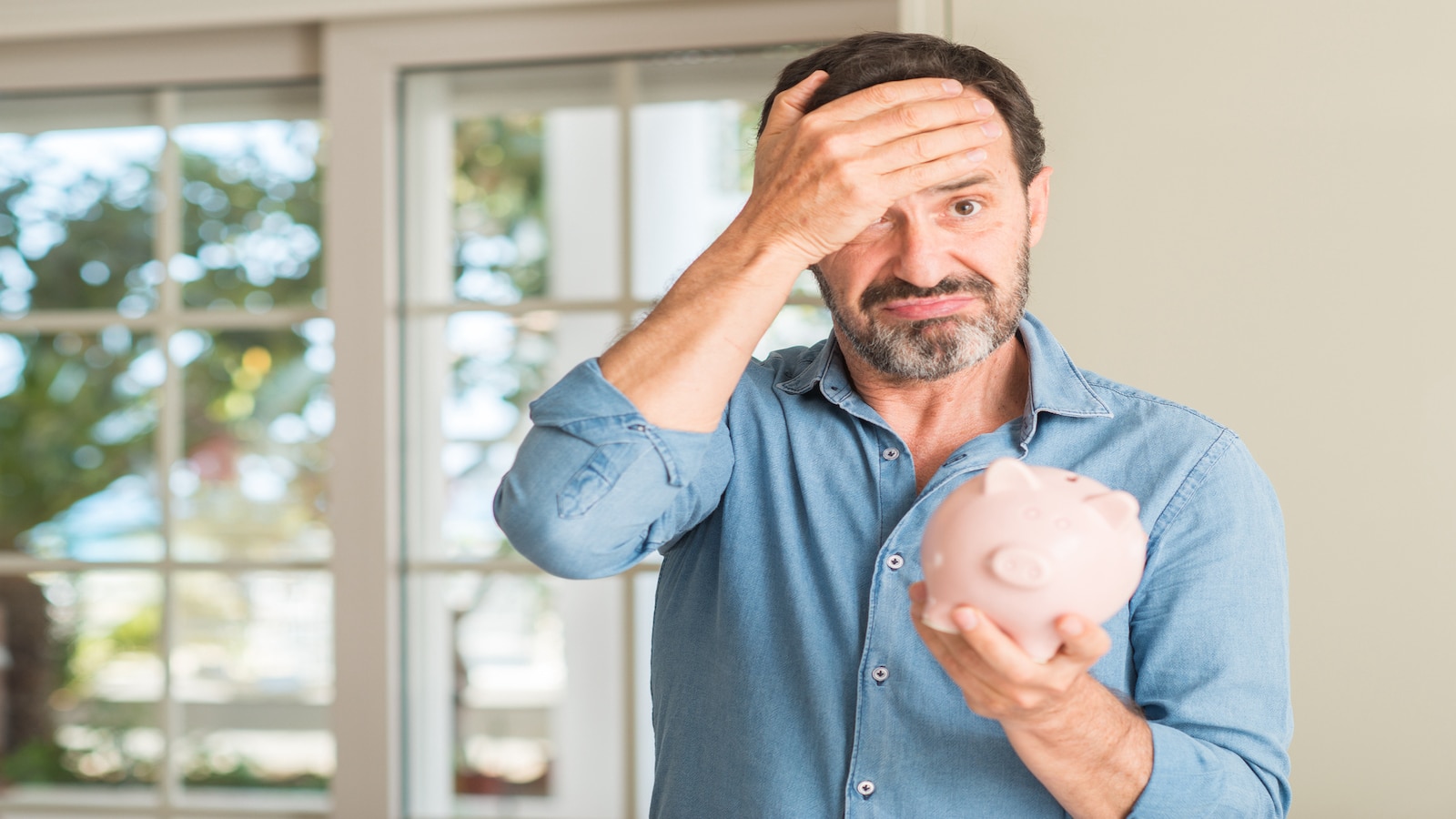 man shocked saving money with piggy bank.