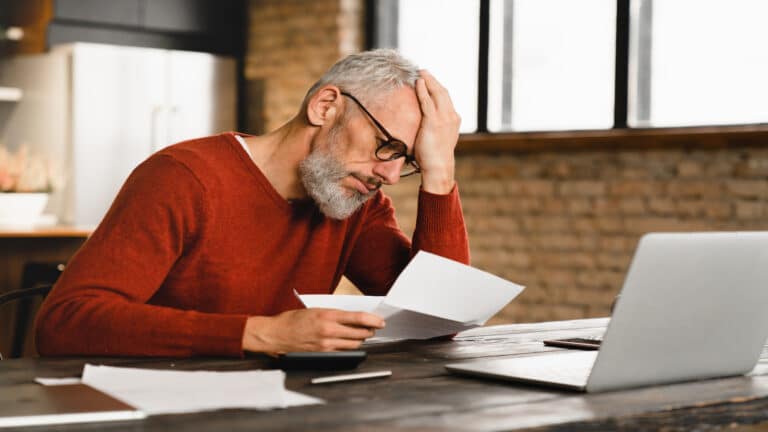 man stressed looking at bills.
