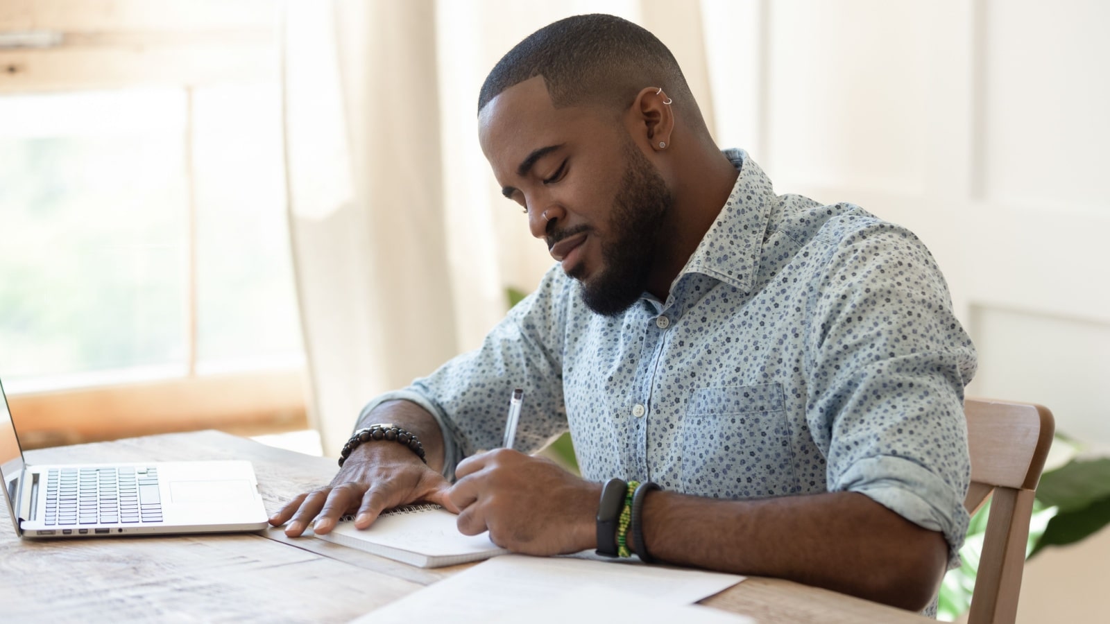 Man writing notes at desk.