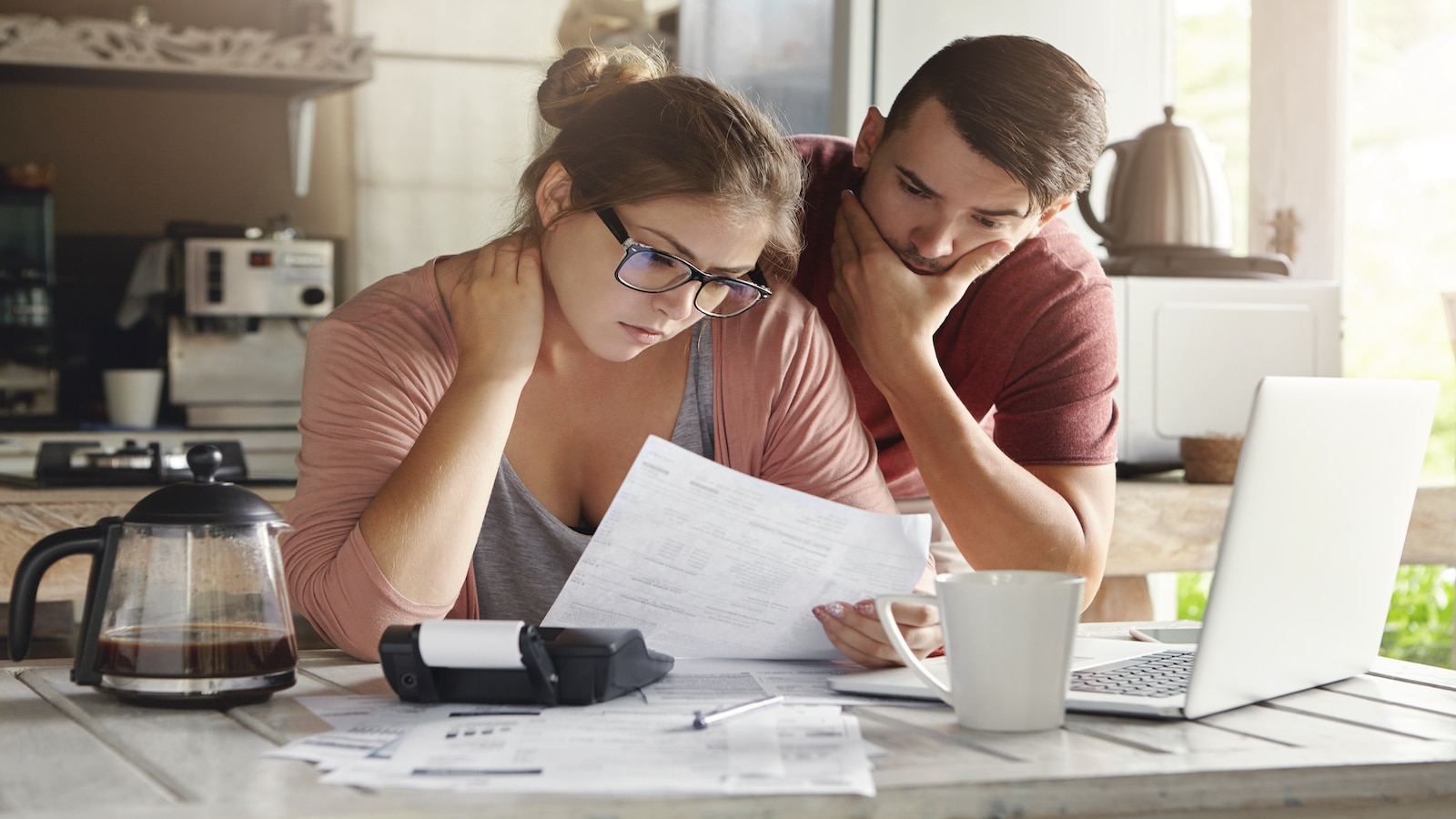 Young couple stresssed with debt money problems, not able to pay bills looking at computer.