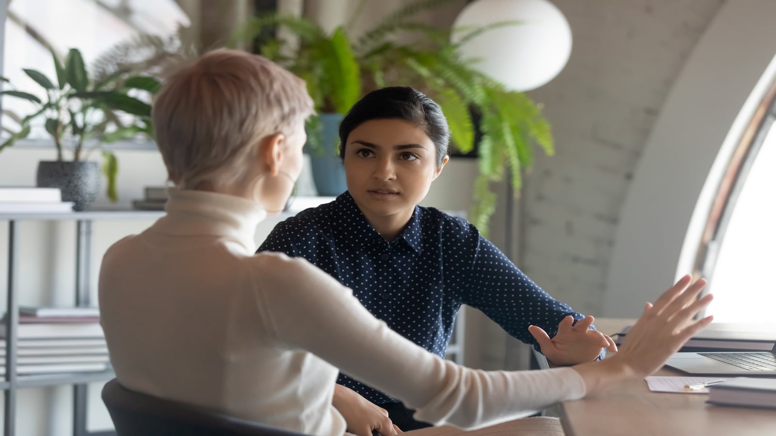 two women having personal discussion in office.