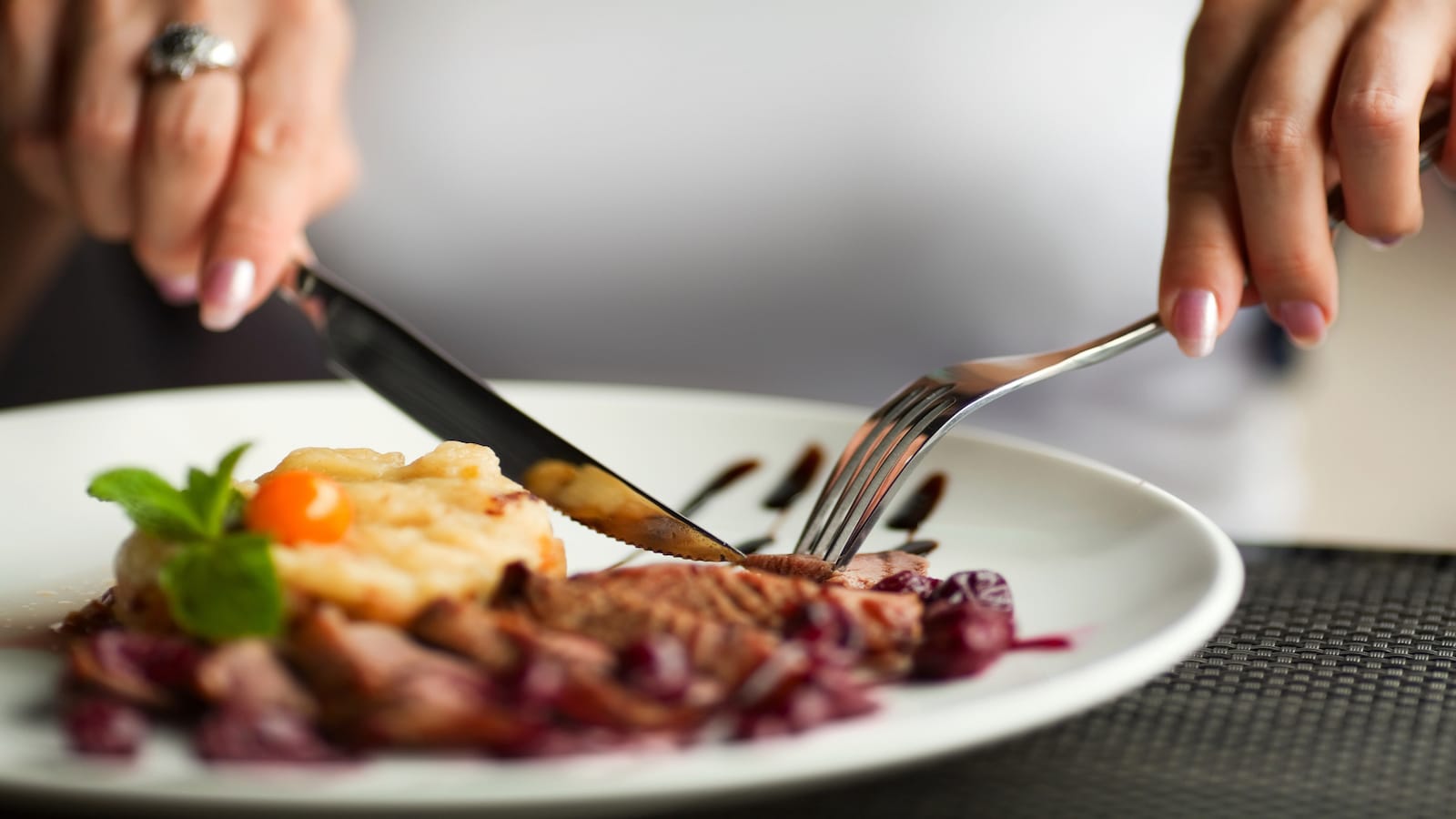 woman cutting meat with knife.