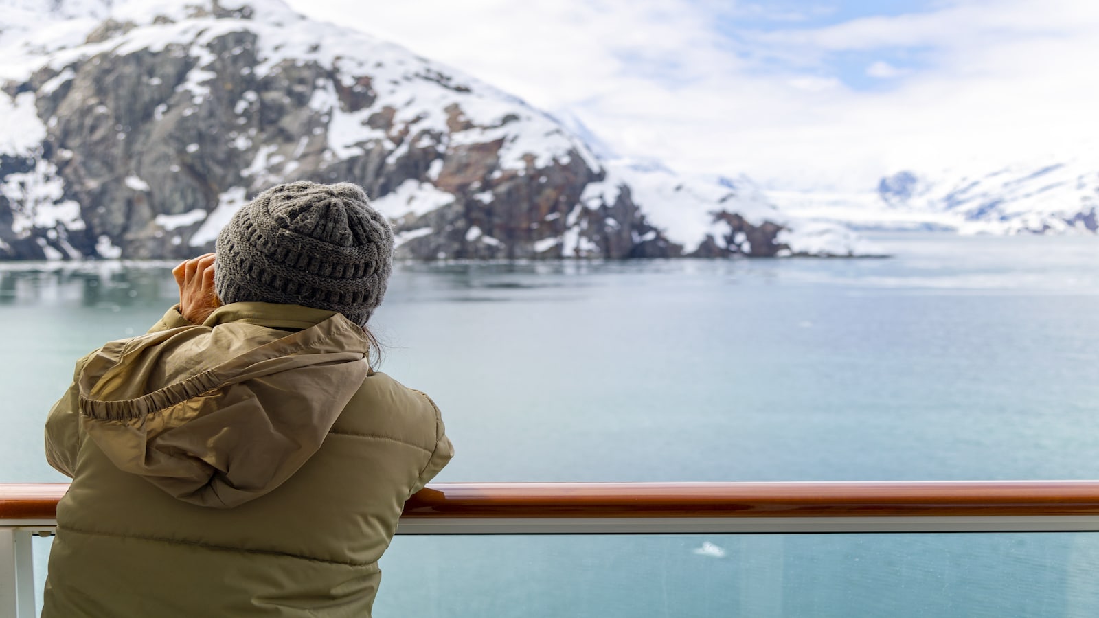 woman looking off cruise ship glacier bay national park and reserve alaska.