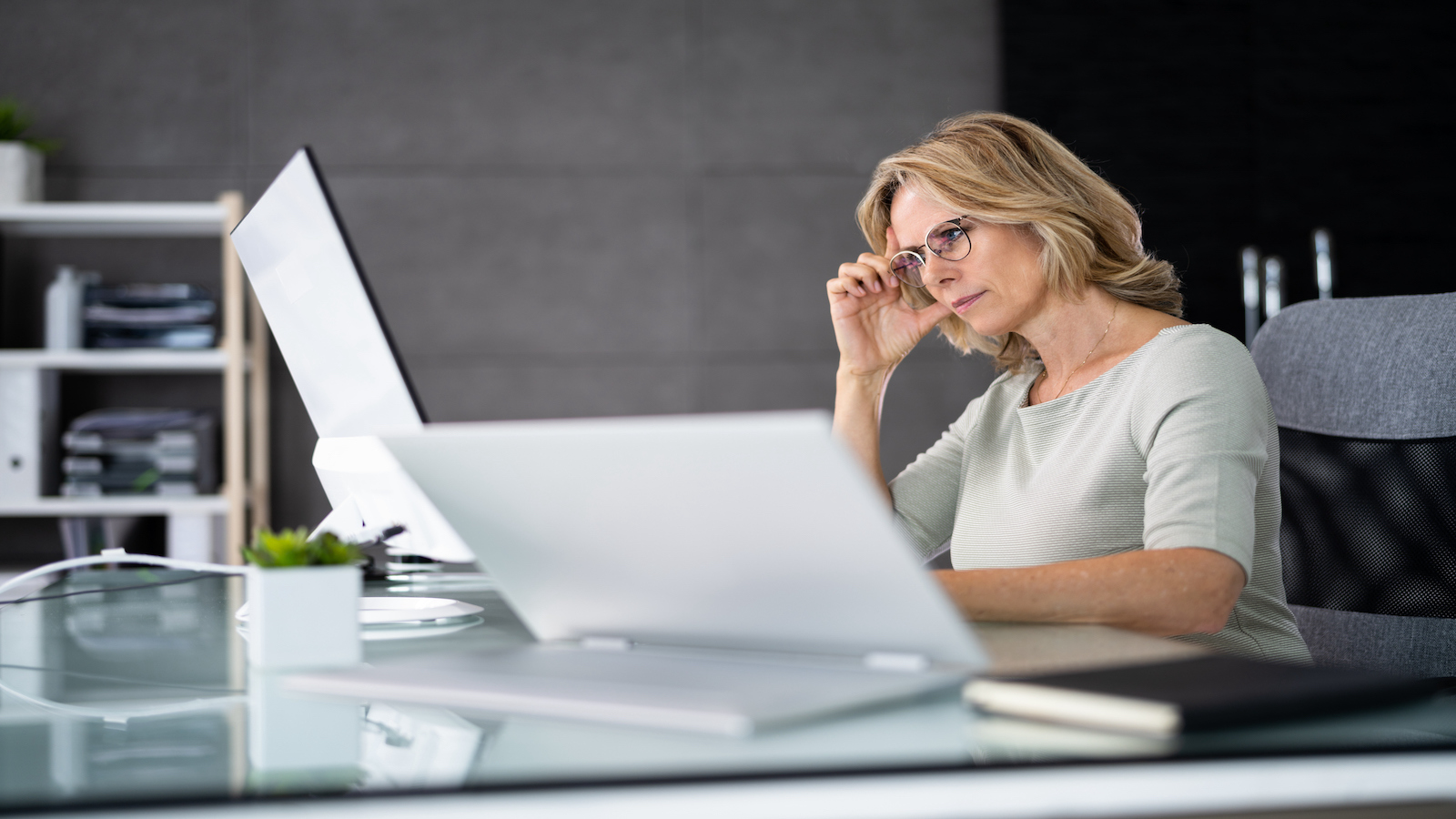 woman looking stressed at computer at work.