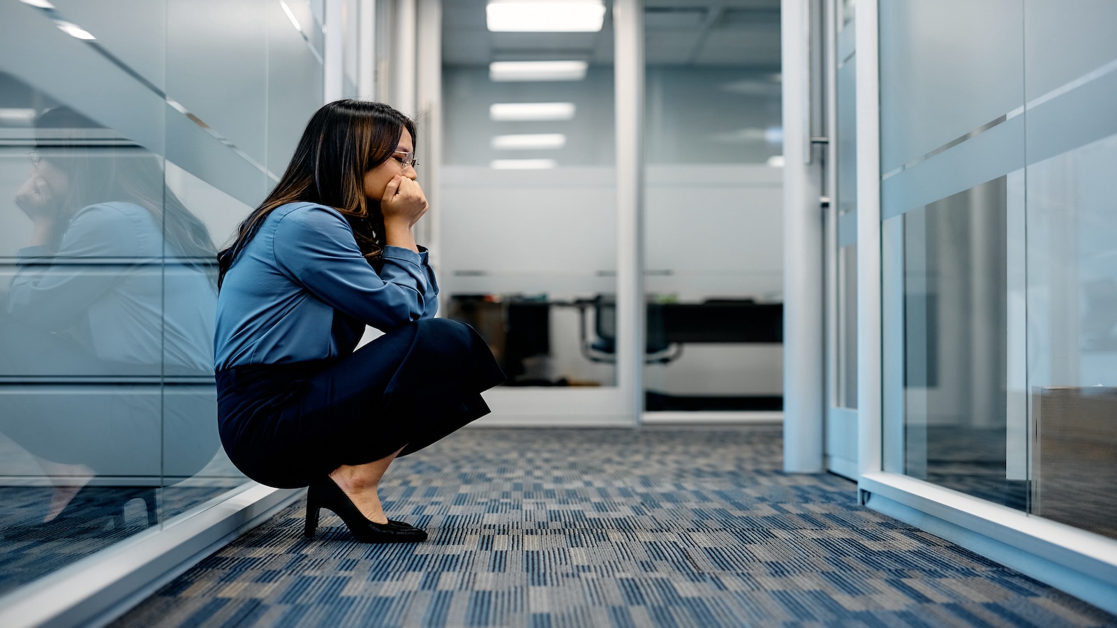 woman stressed out at work in hallway.