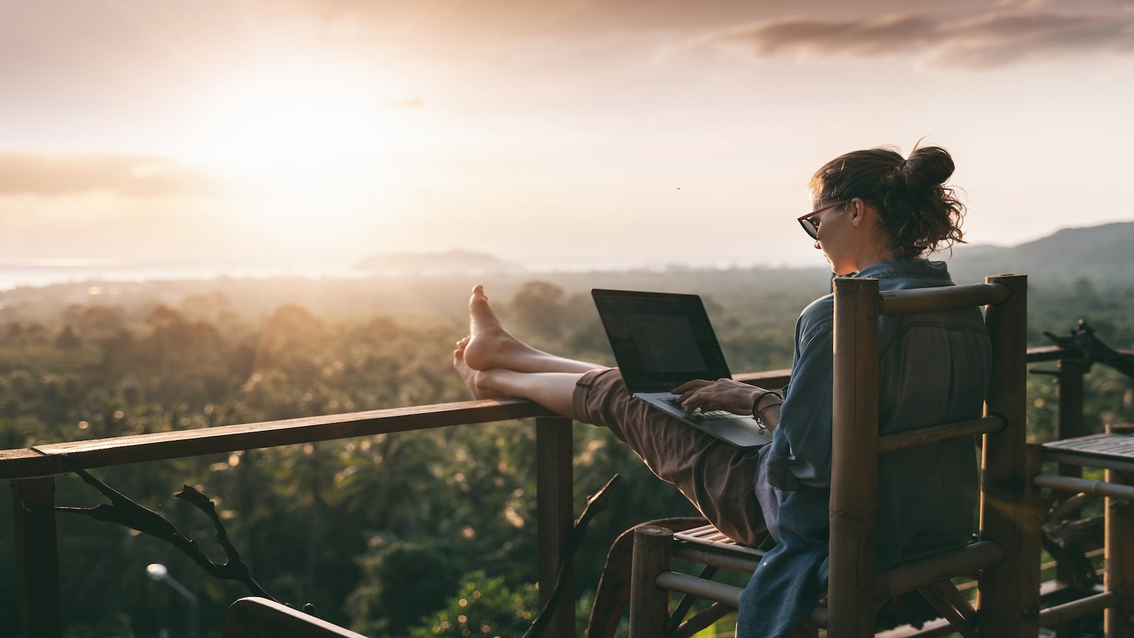 woman on porch working and watching sun set.