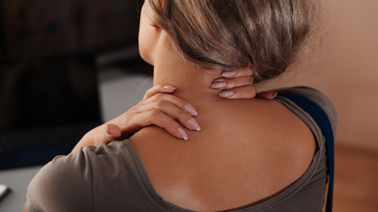 Woman rubbing neck accupressure points.