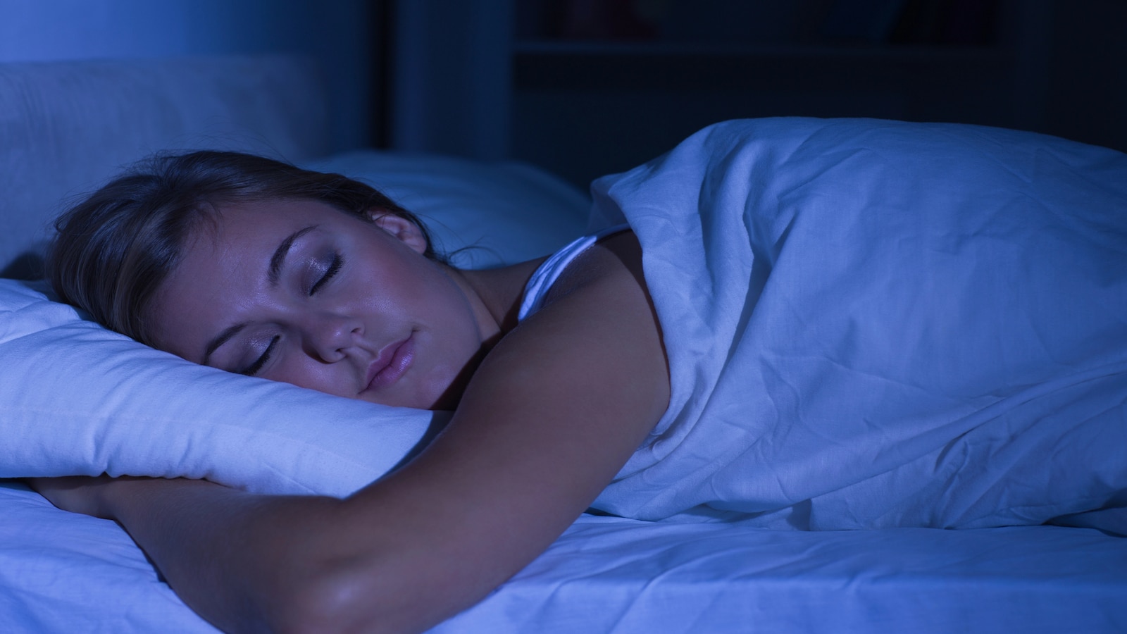 Woman sleeping at night in dark room.