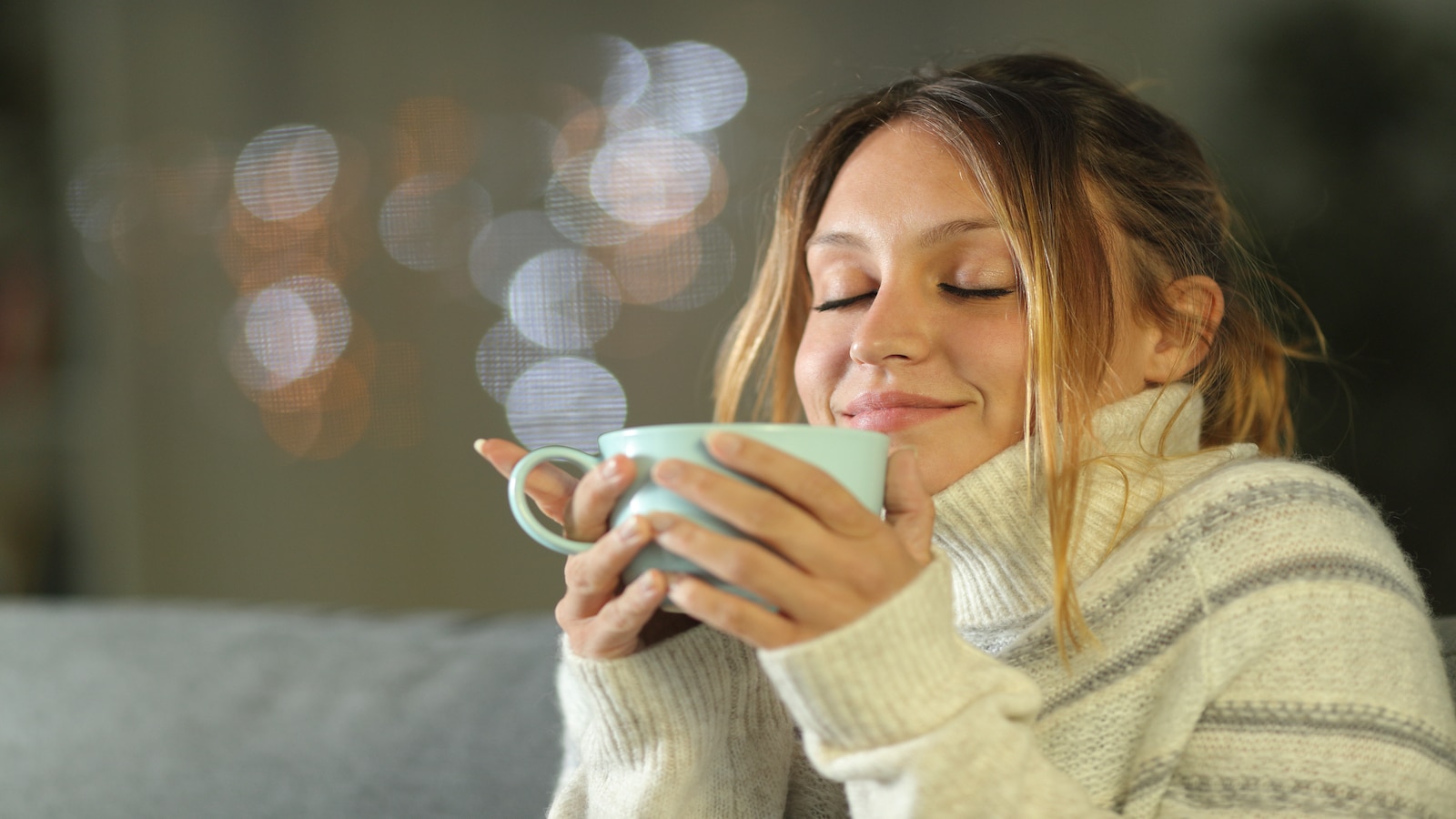 Woman relaxed smiling drinking cup of coffee tea.