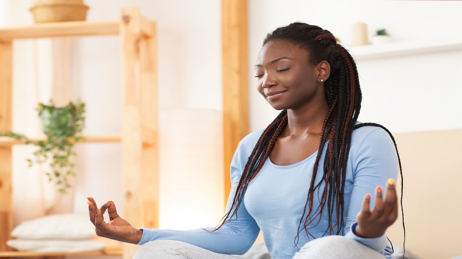 Woman smiling meditating in house.