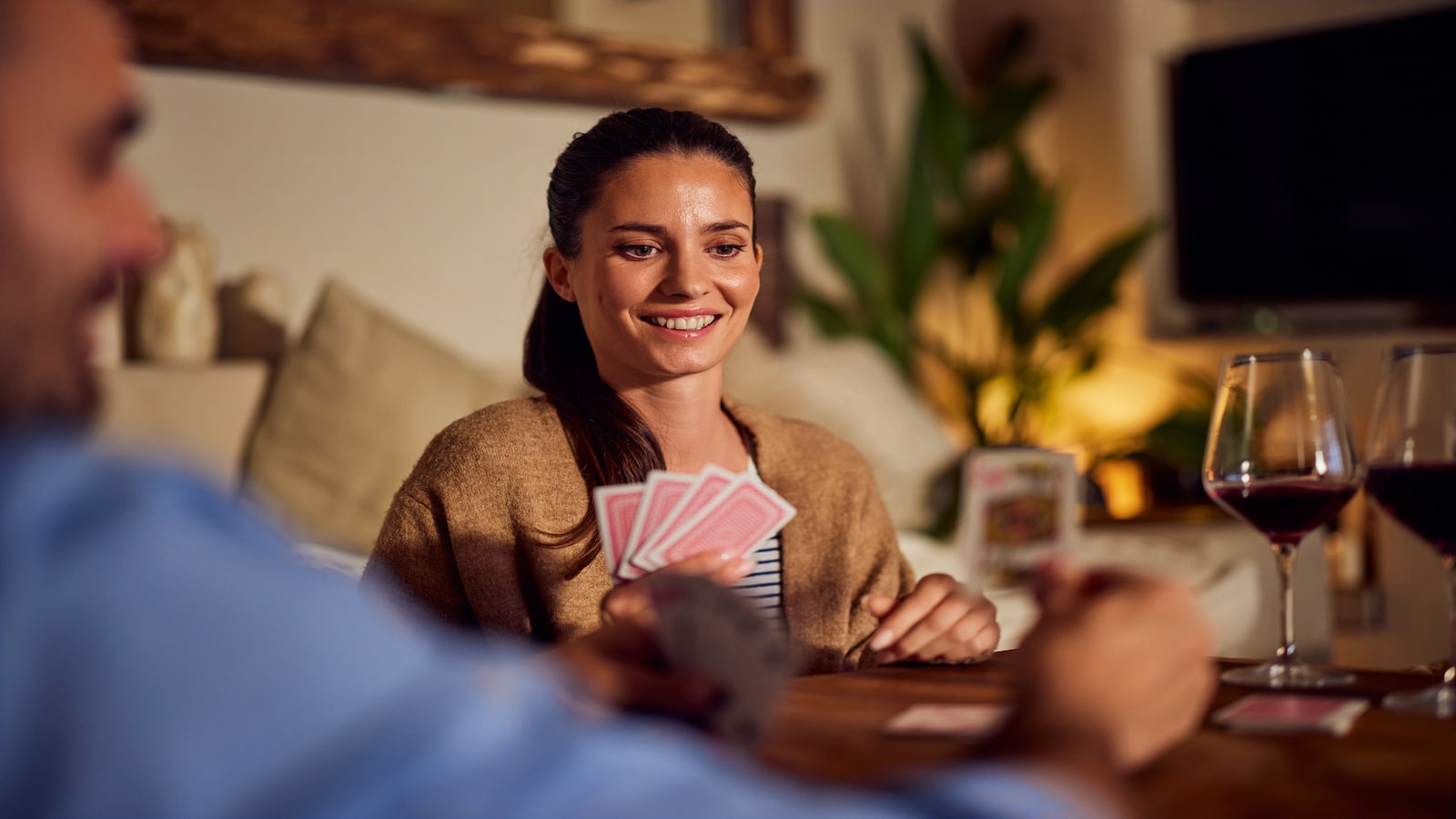Woman smiling playing cards at home date night.